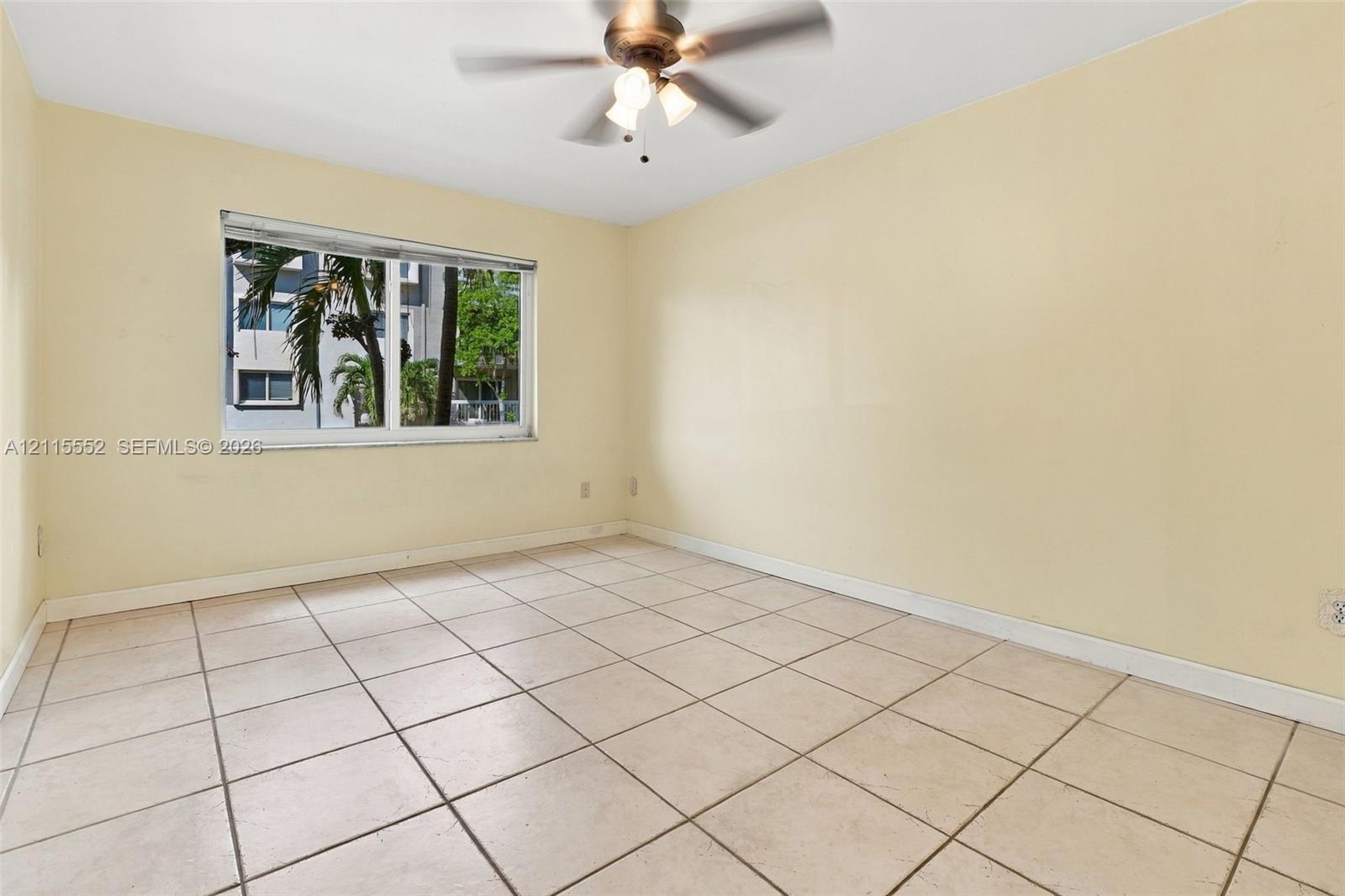 Neutral-toned ceramic tile flooring, horizontal sliding window, and central ceiling fan with integrated light fixture