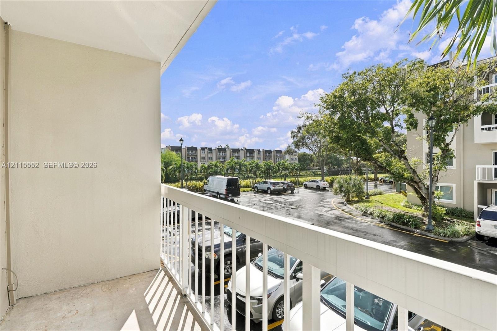 Private balcony featuring white metal railing, solid surface flooring, and smooth-finish walls