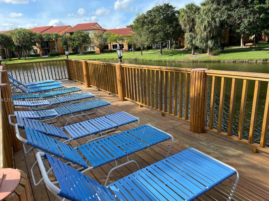 Waterfront wooden deck featuring built-in vertical post lighting and a perimeter railing