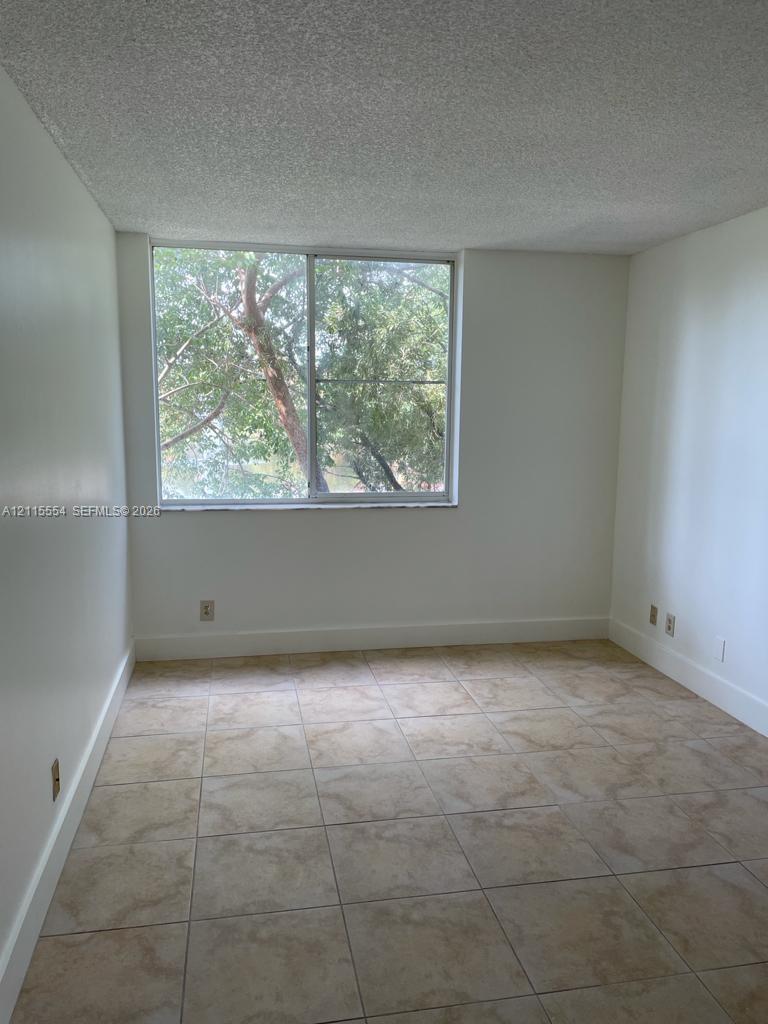 Interior space featuring large-format ceramic tile flooring, neutral wall finishes, and a single sliding window