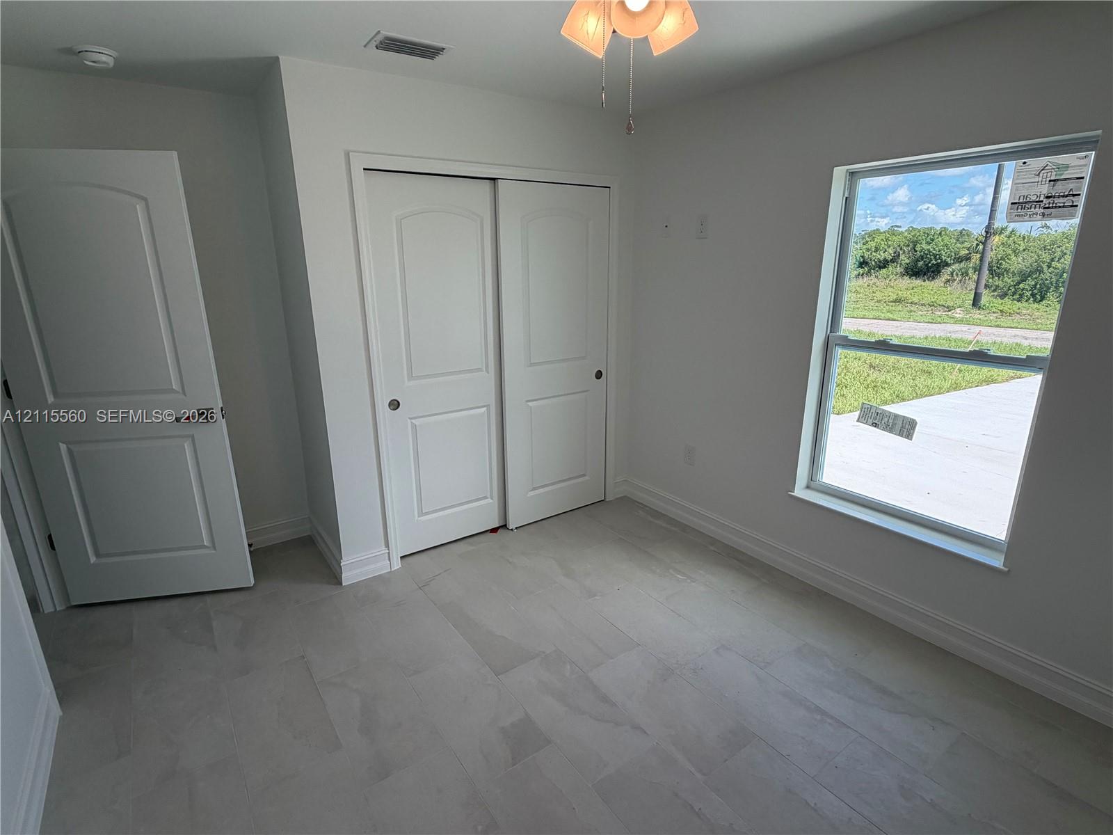 Neutral-toned tile flooring, two-panel interior doors, double-door reach-in closet, and single-hung window
