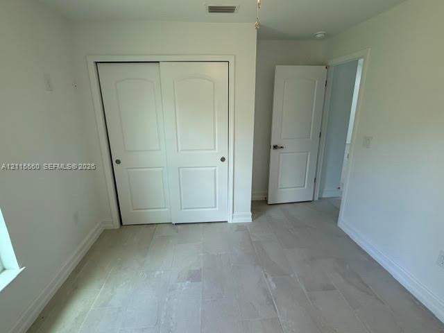 Neutral-toned tile flooring, two-panel interior doors, and closet with sliding panel doors