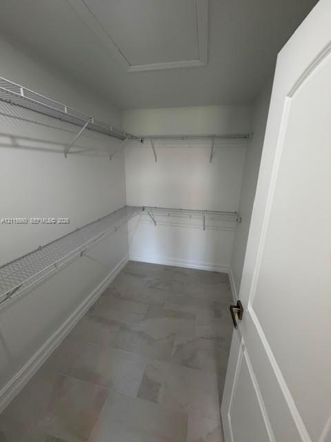 Storage space featuring large-format ceramic tile flooring and wrap-around white wire shelving