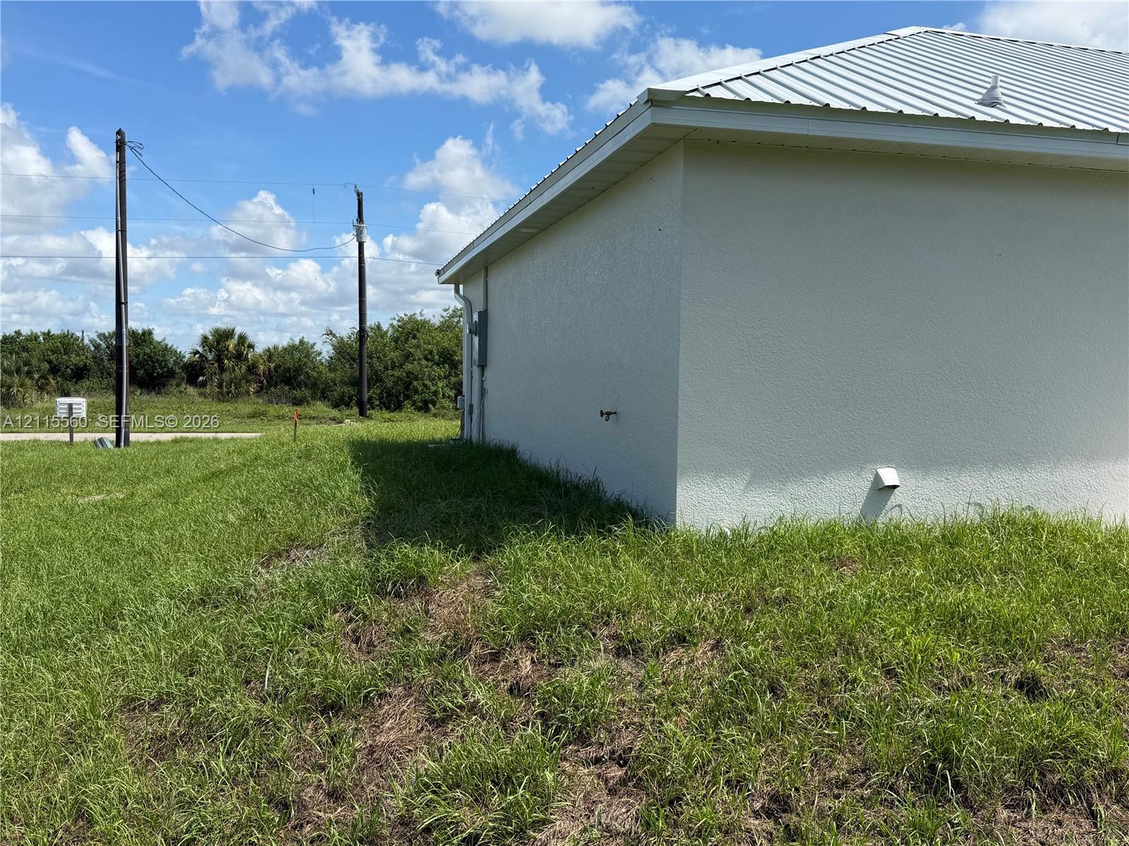 Exterior side profile featuring a metal roof and stucco siding