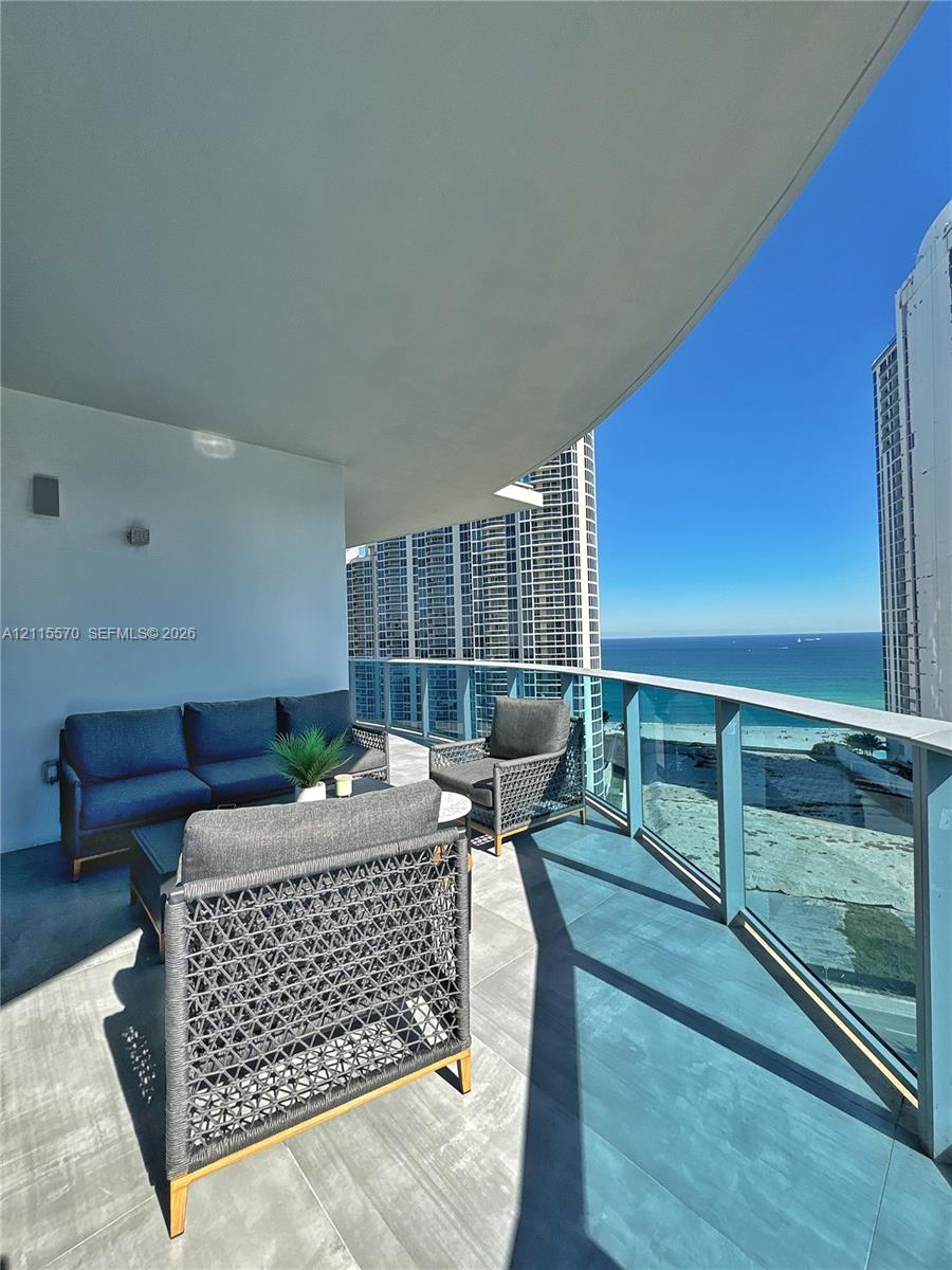 Private balcony featuring large-format tile flooring and a glass railing system