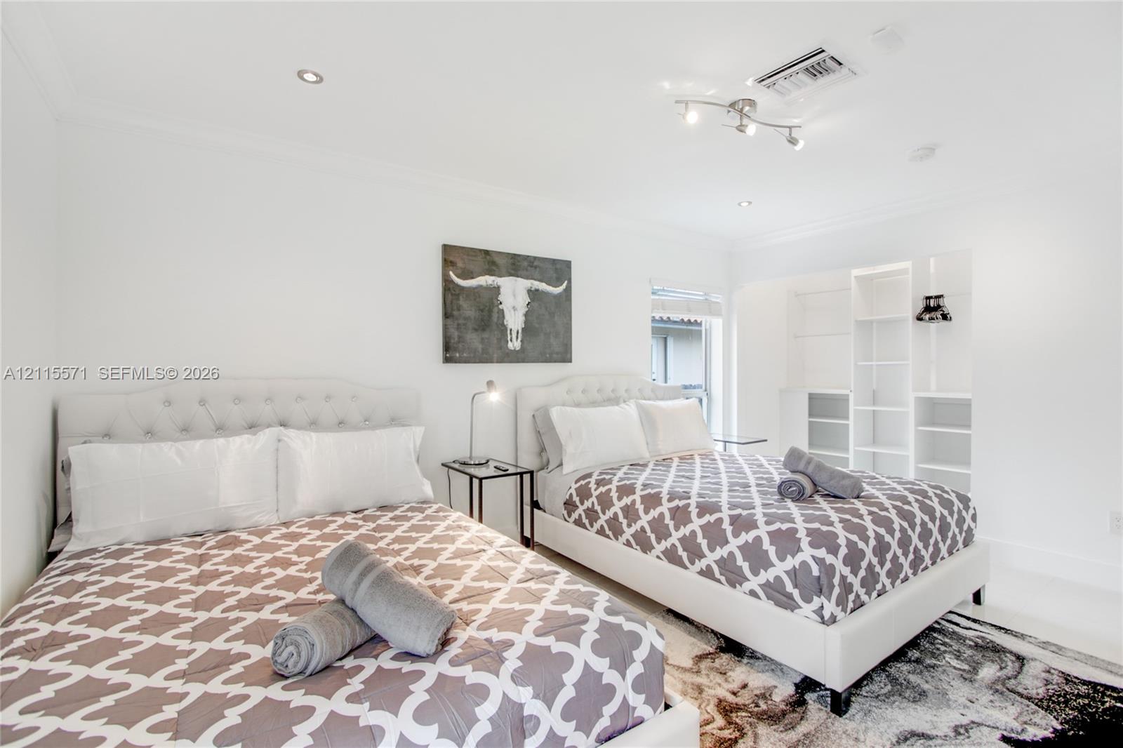 Room featuring recessed ceiling lighting, multi-bulb track lighting, and built-in white shelving