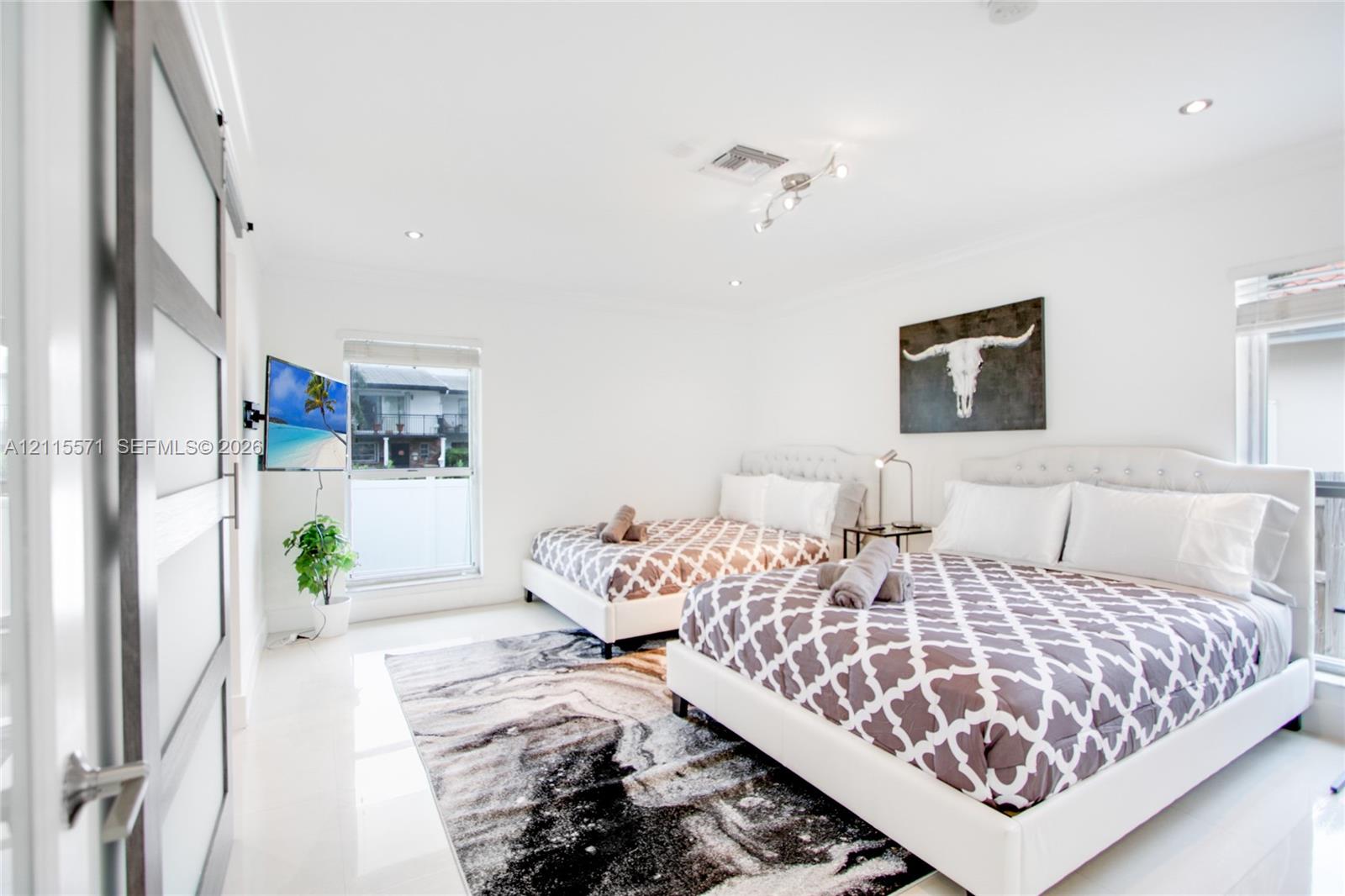 Bedroom featuring recessed lighting, large-format tile flooring, and a sliding barn-style door with frosted glass panels