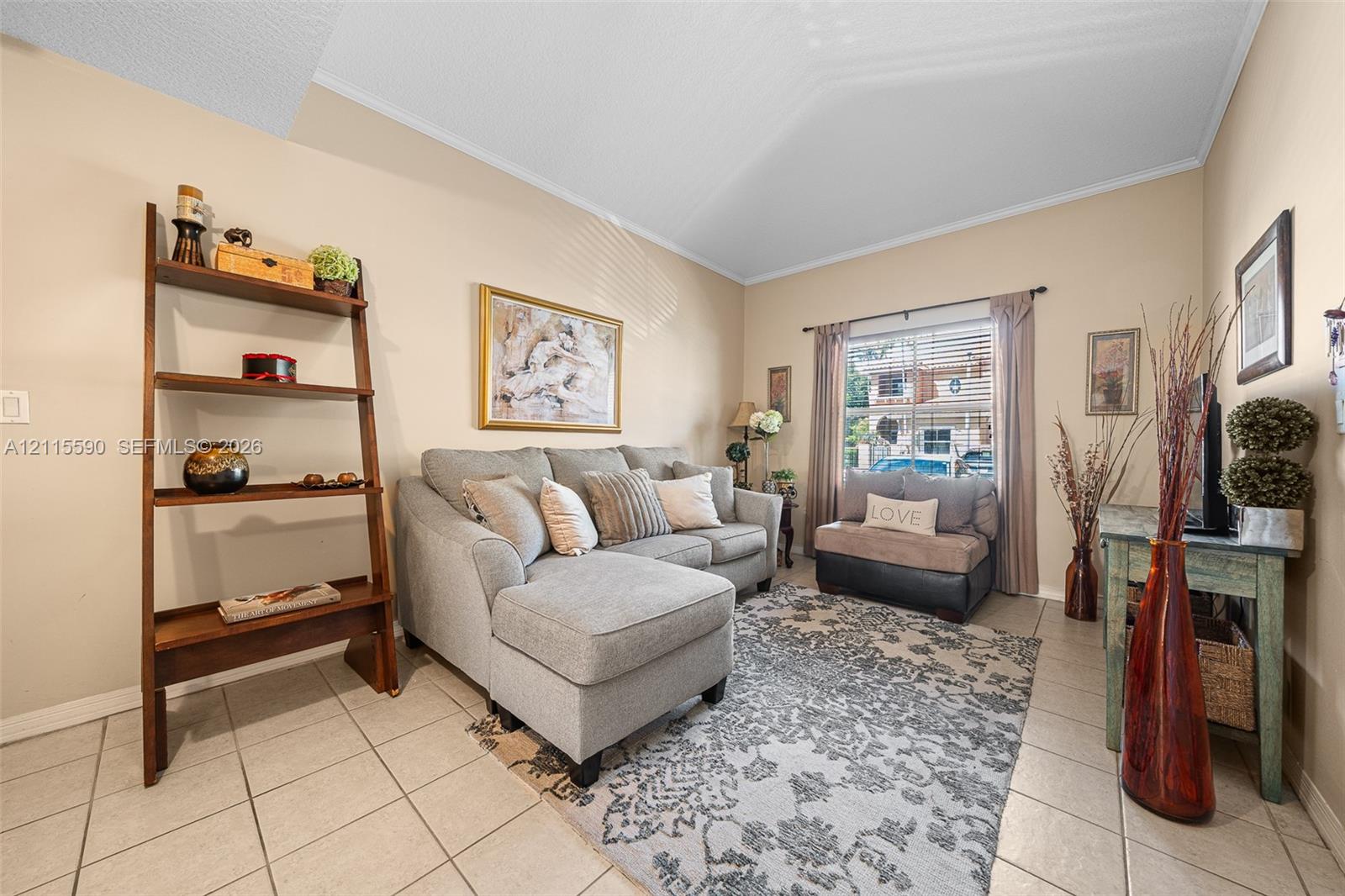 Vaulted ceilings, neutral wall tones, large window with horizontal blinds, and ceramic tile flooring