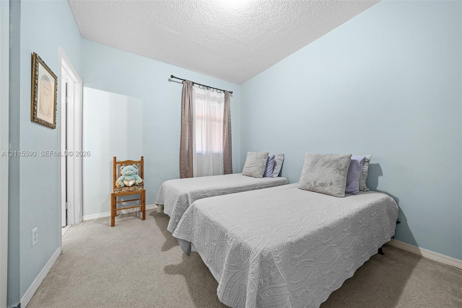 Room featuring neutral carpeting, light-toned wall paint, and a window with a mounted rod