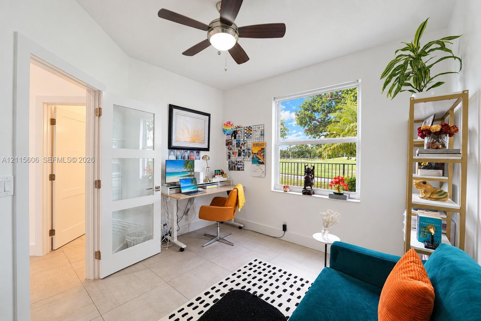 Neutral-toned tile flooring, three-panel glass-inset interior door, ceiling-mounted light fixture with fan, and a single-hung window