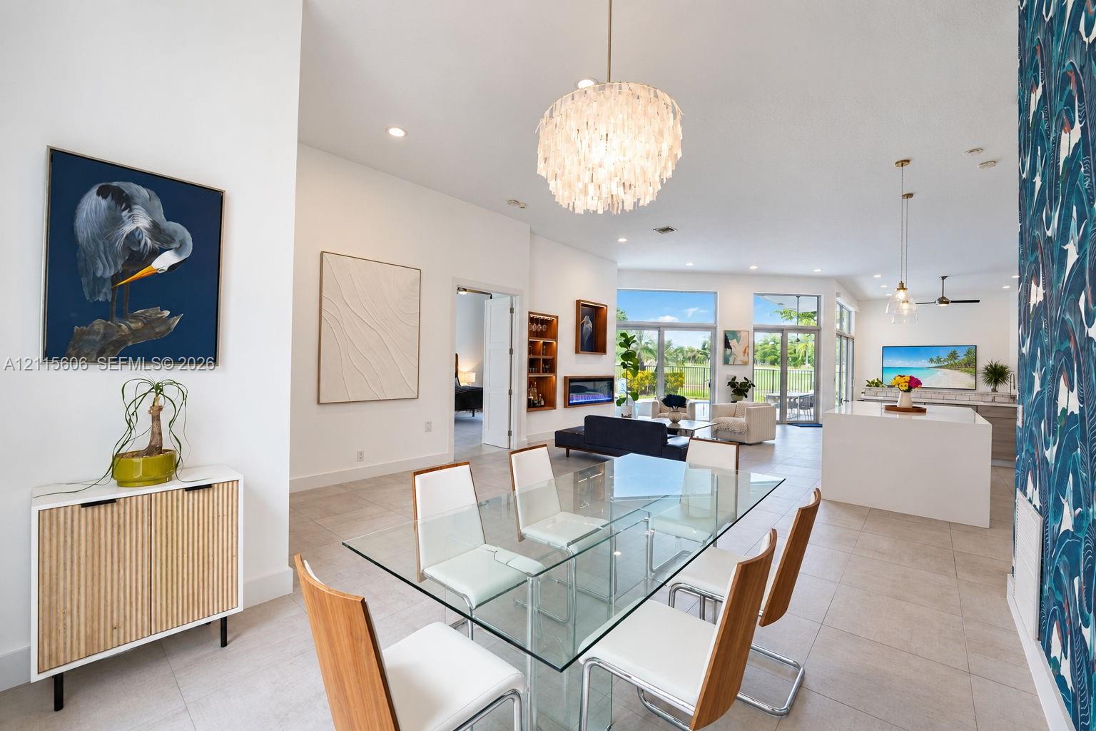 Open-concept interior featuring high ceilings, large-format tile flooring, recessed lighting, a built-in linear fireplace, and expansive glass doors