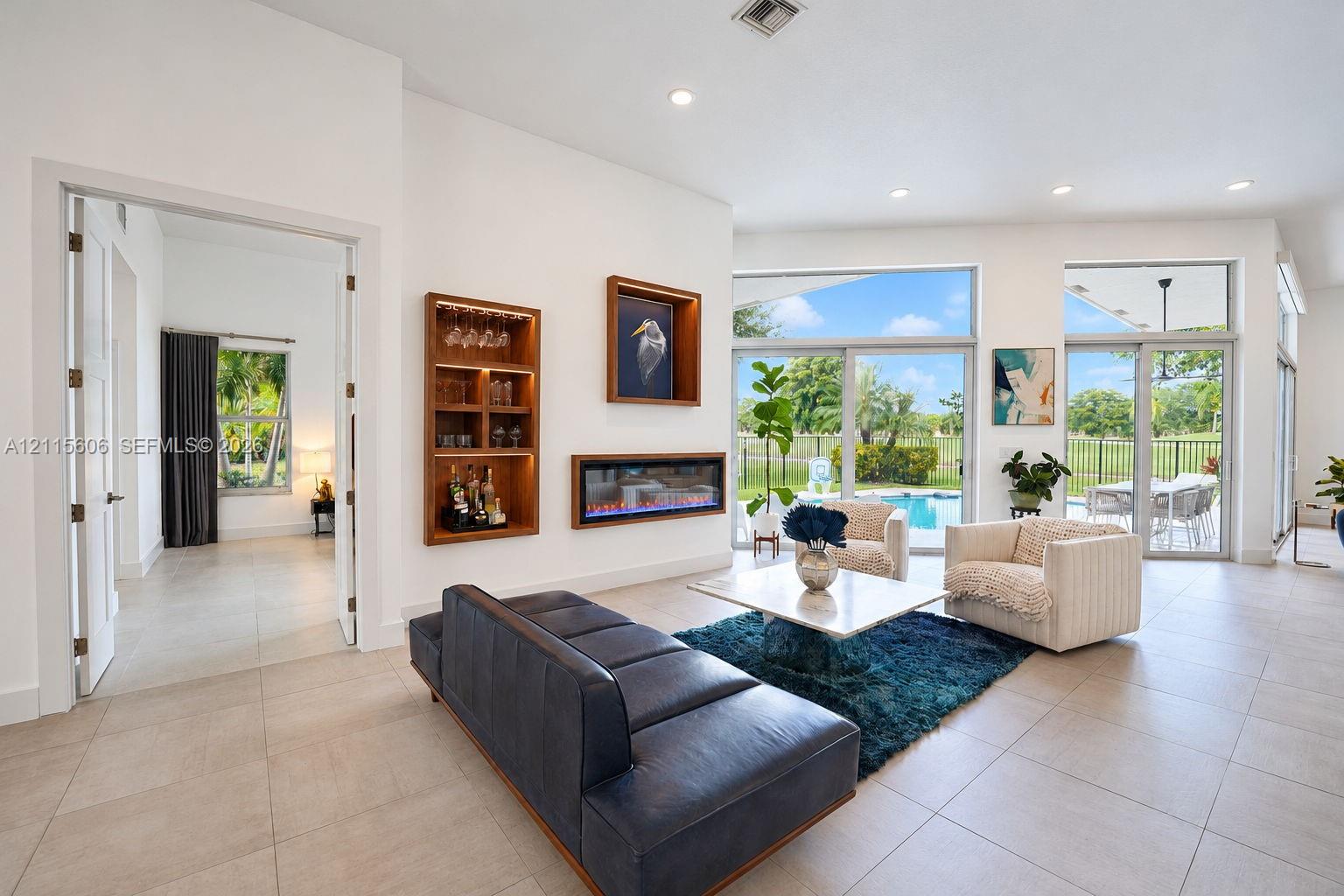 Living area featuring large-format tile flooring, recessed lighting, a linear electric fireplace, and floor-to-ceiling glass sliding doors