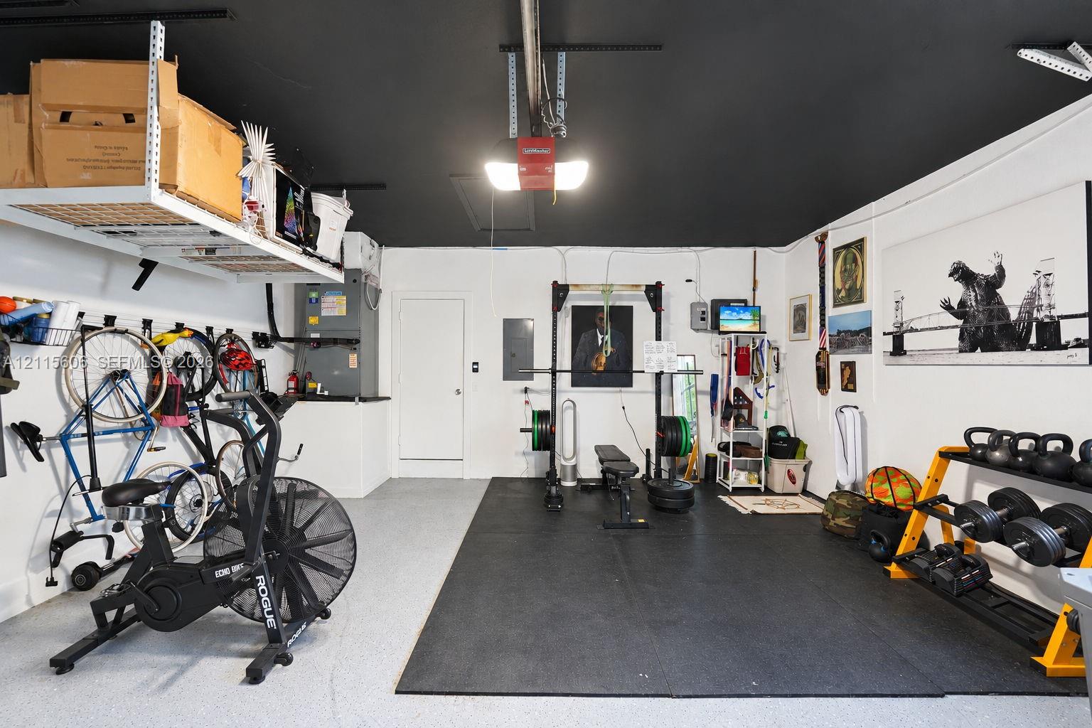 Garage space featuring epoxy-coated flooring, painted ceiling, and wall-mounted overhead storage shelving