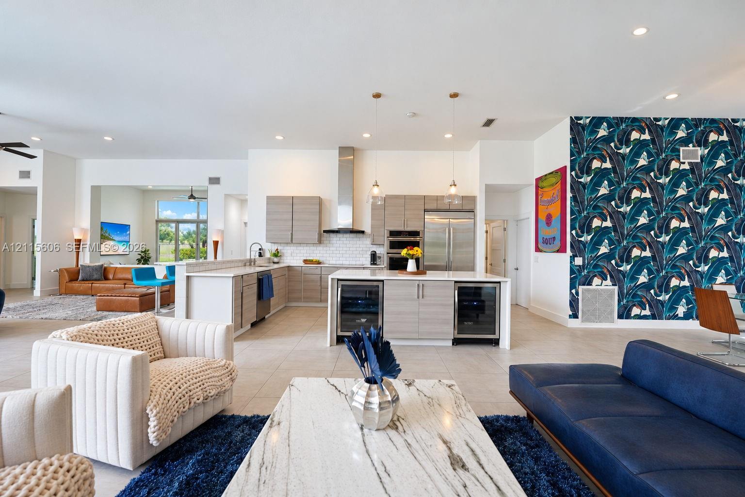 Kitchen featuring custom horizontal-grain cabinetry, stainless steel appliances, a subway tile backsplash, and a central island with dual under-counter beverage refrigerators