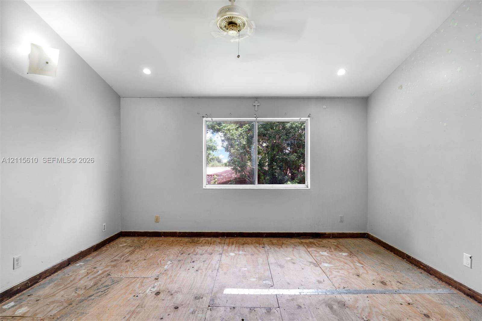 Room featuring neutral wall finishes, recessed lighting, a ceiling fan, and a centered window with natural landscape exposure