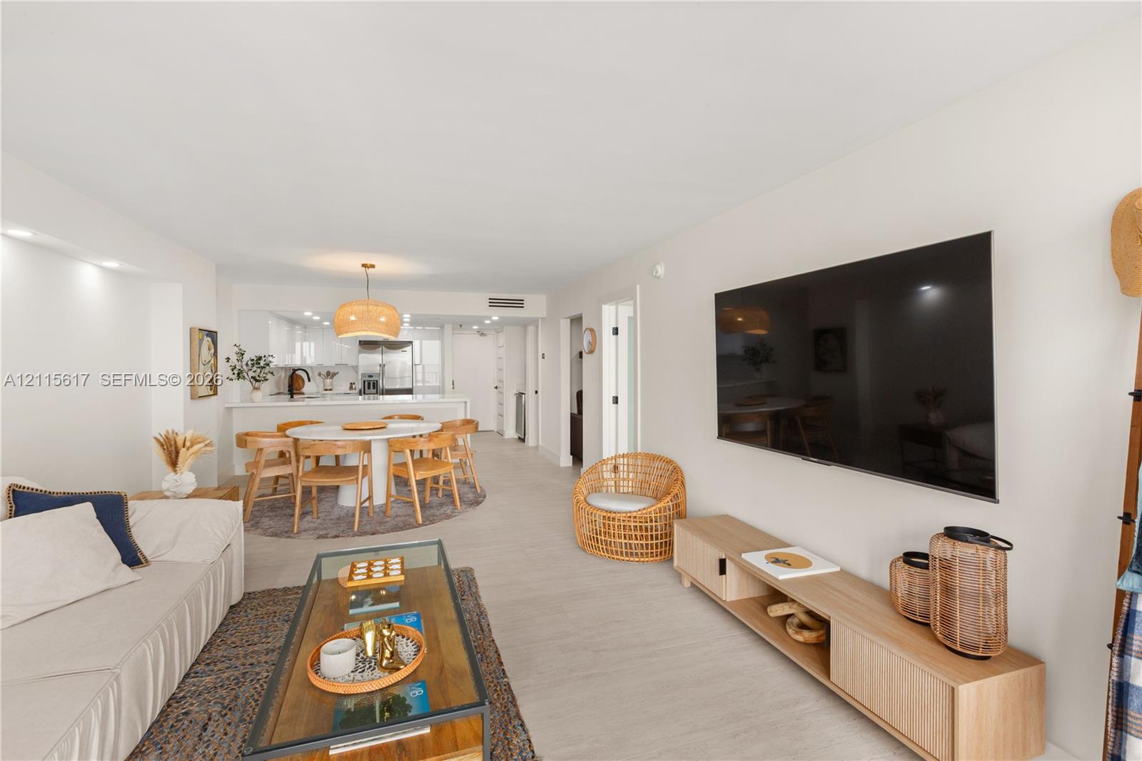 Open-concept interior featuring light wood-finish flooring, recessed lighting, and a neutral color palette