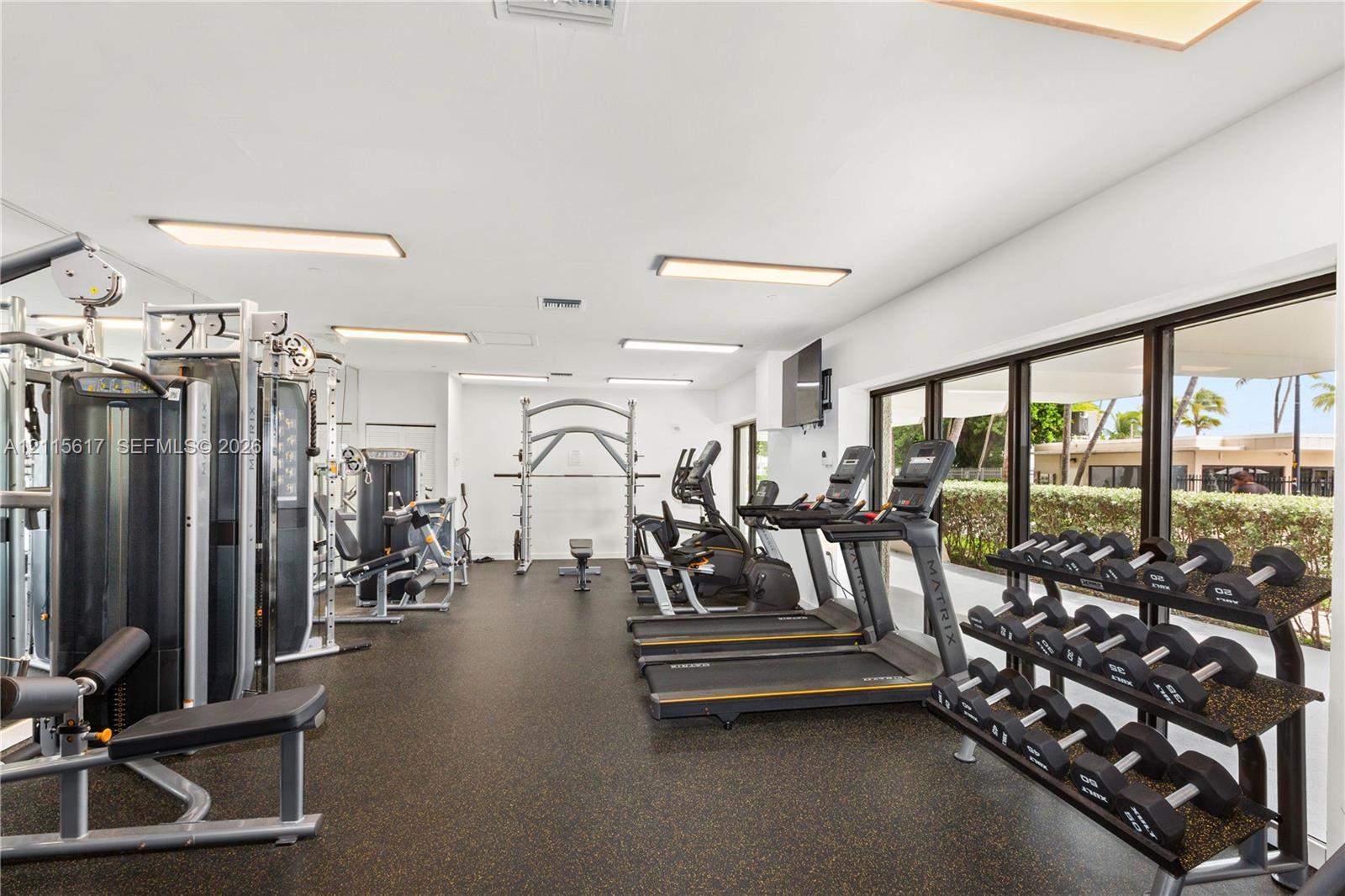 Fitness center featuring rubberized flooring, recessed lighting, and floor-to-ceiling windows