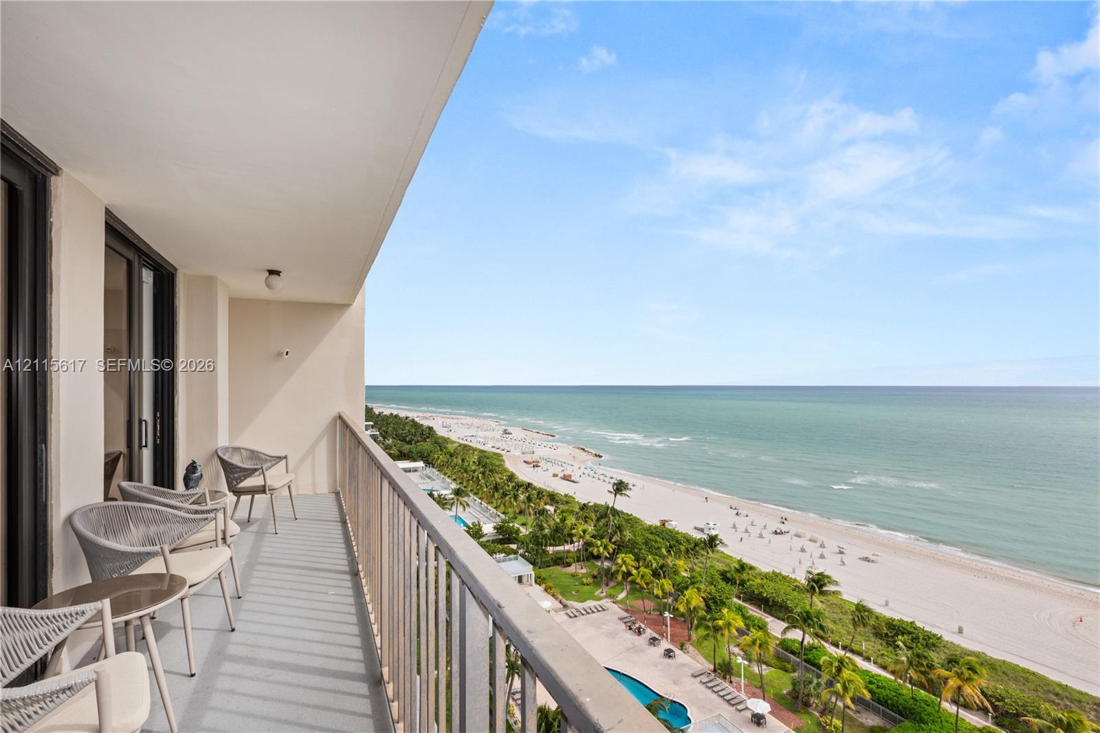 Covered balcony featuring a metal railing and tile flooring, providing an expansive coastal backdrop