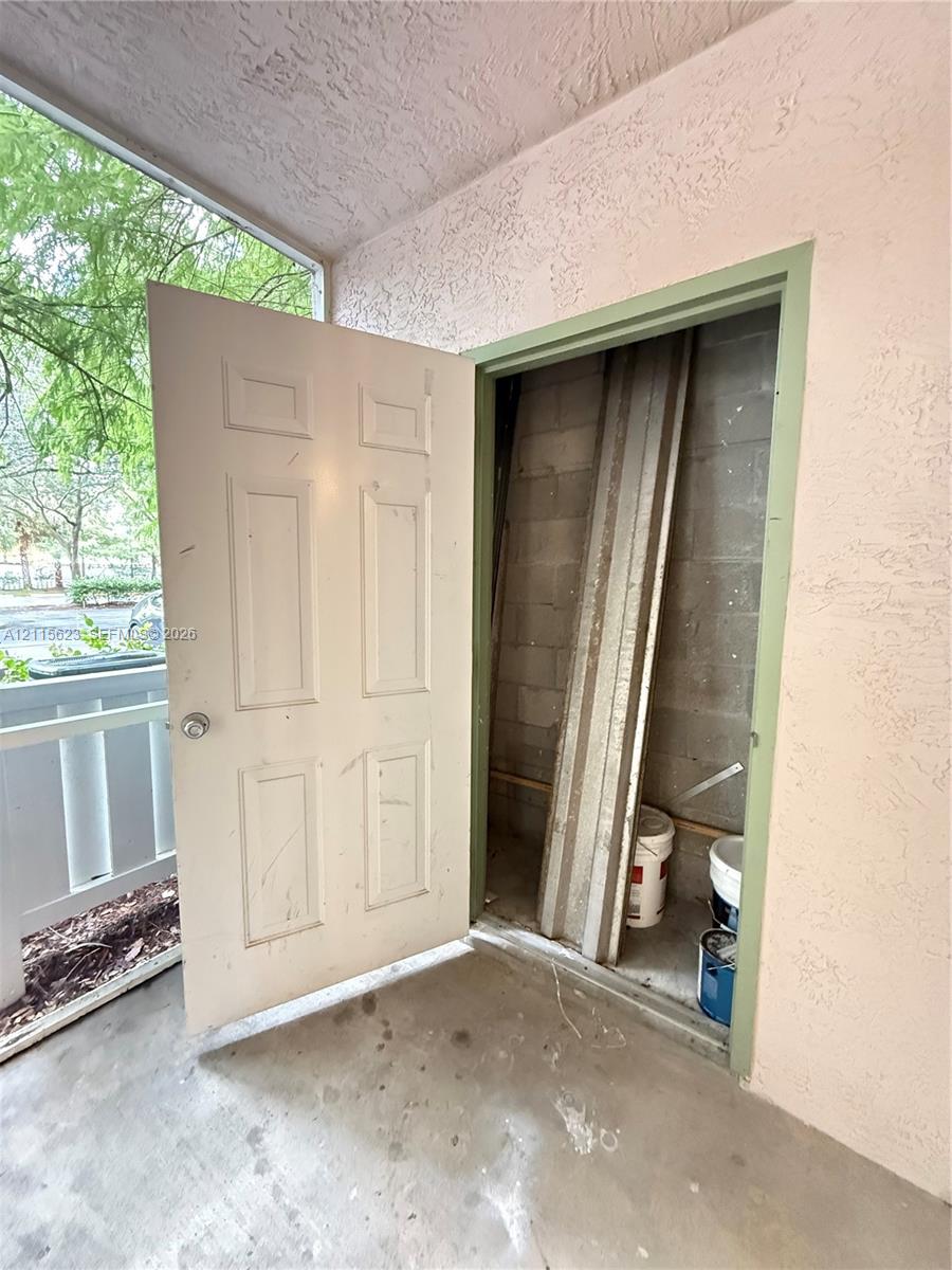 Exterior storage closet with a six-panel door and concrete masonry unit walls