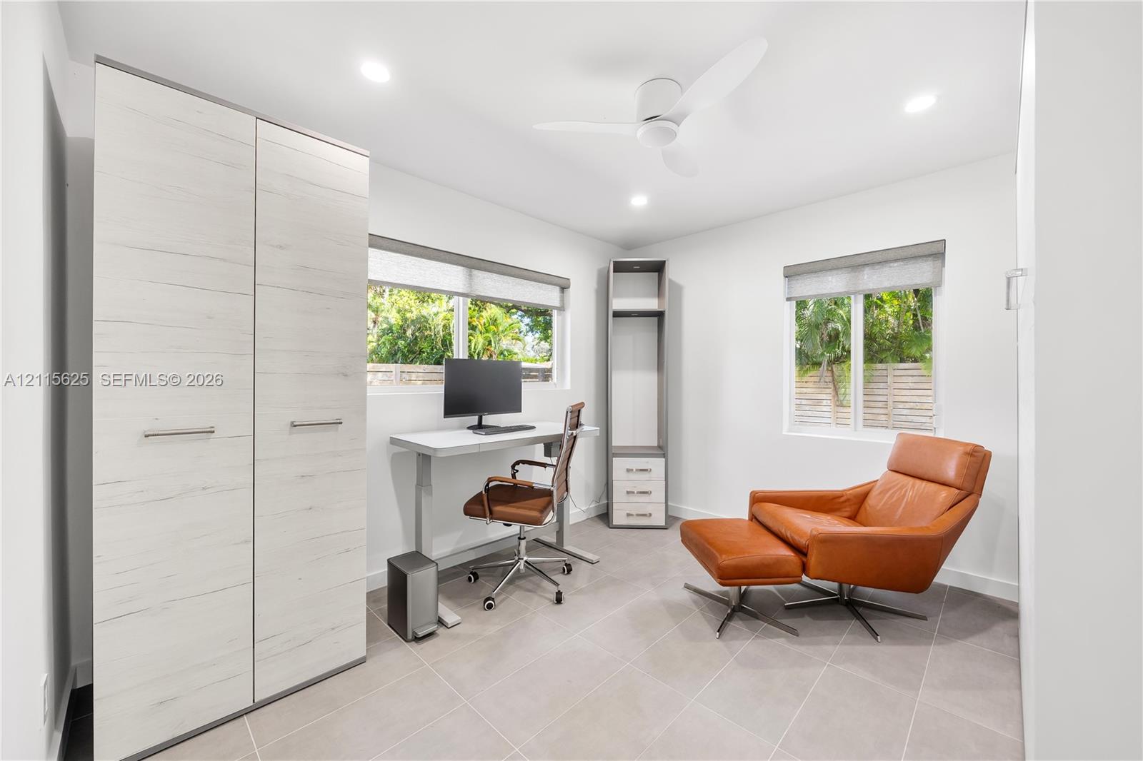 Room featuring light-toned tile flooring, built-in floor-to-ceiling cabinetry, recessed lighting, and a ceiling fan