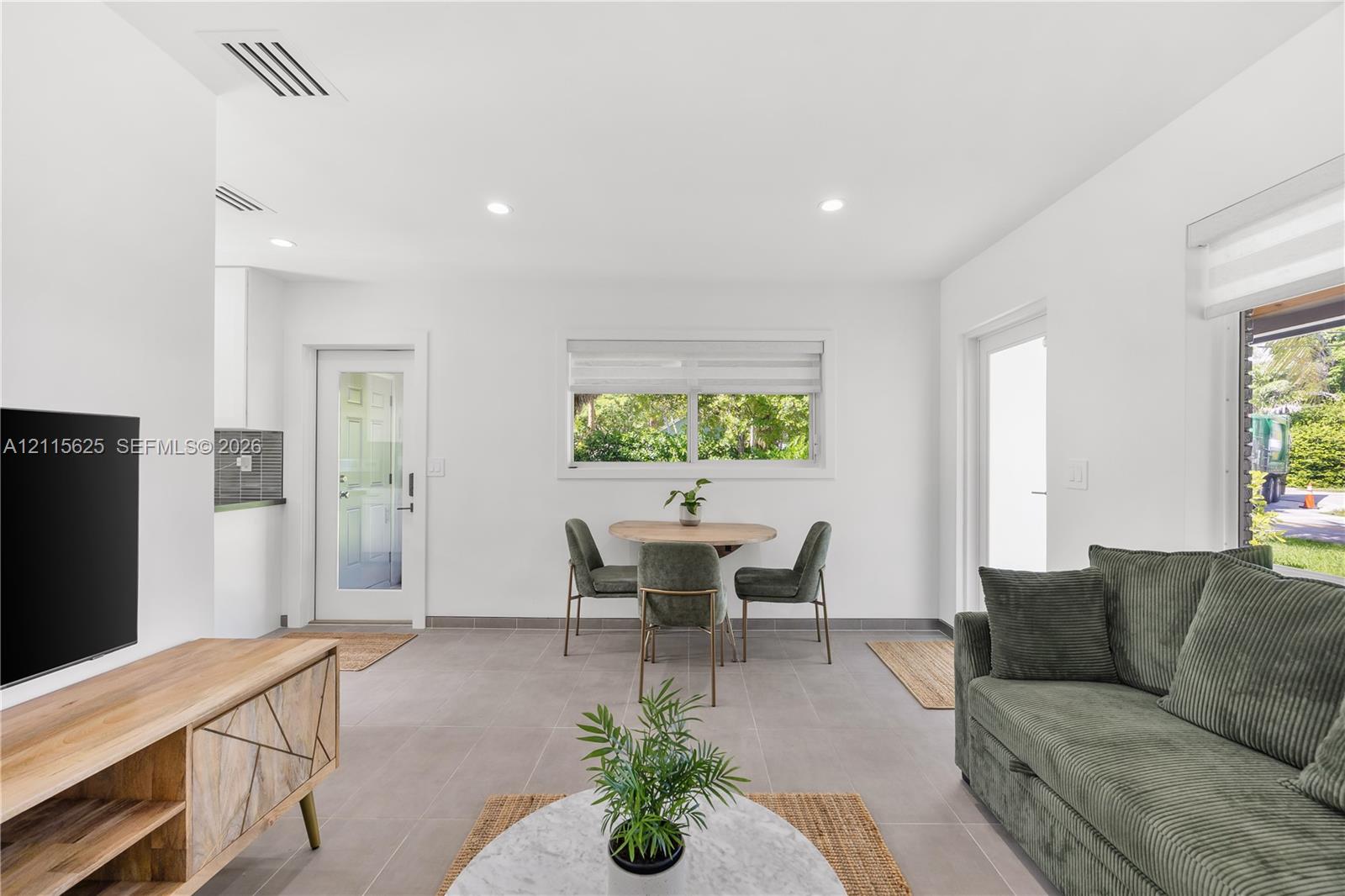 Open-concept space featuring large-format tile flooring, recessed lighting, and expansive windows