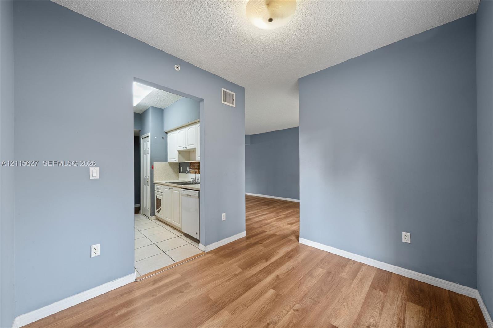 Interior space featuring blue painted walls, wood-finish flooring, and a flush-mount ceiling fixture