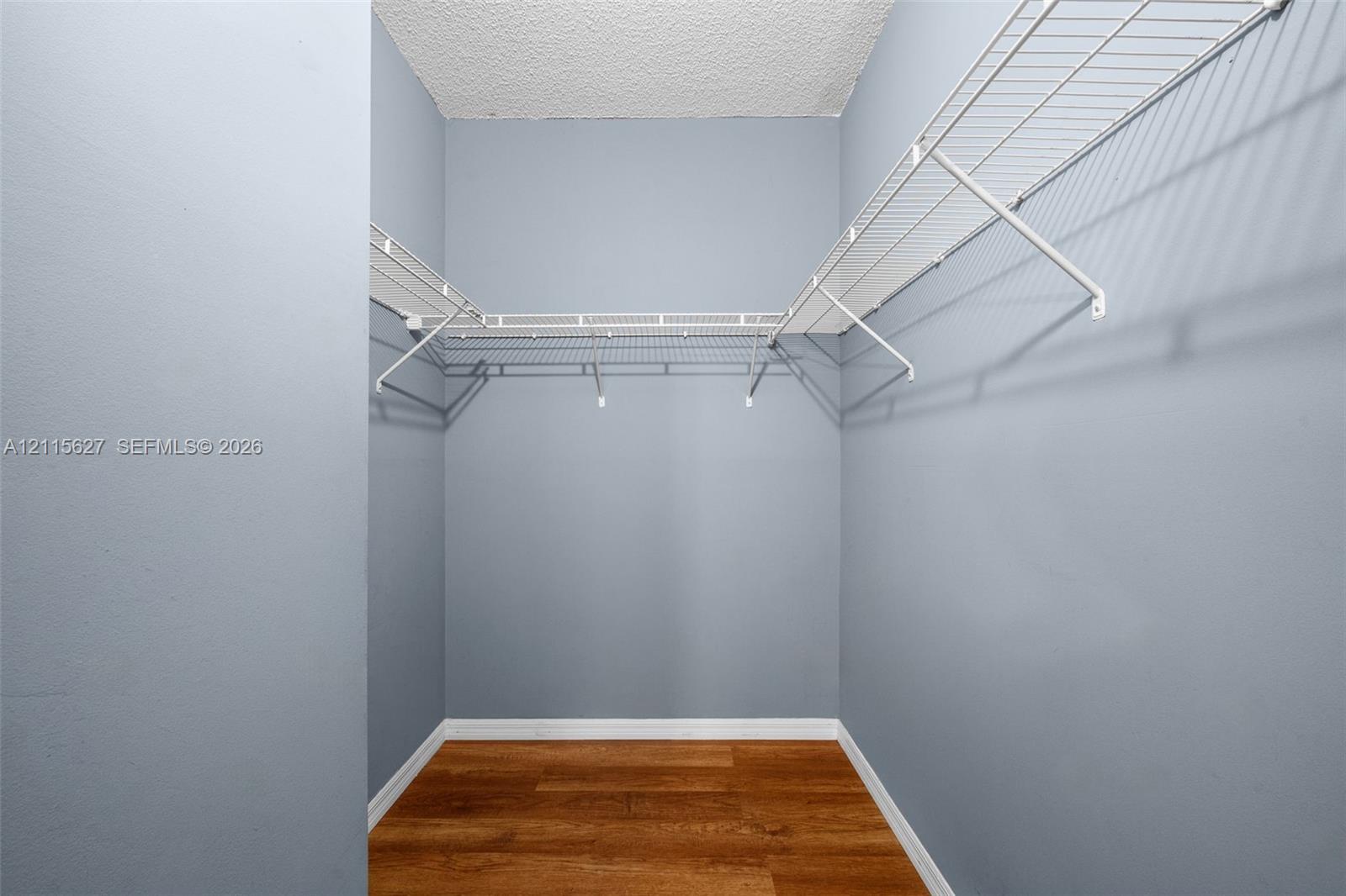 Storage area featuring wood-finish flooring and white wire shelving