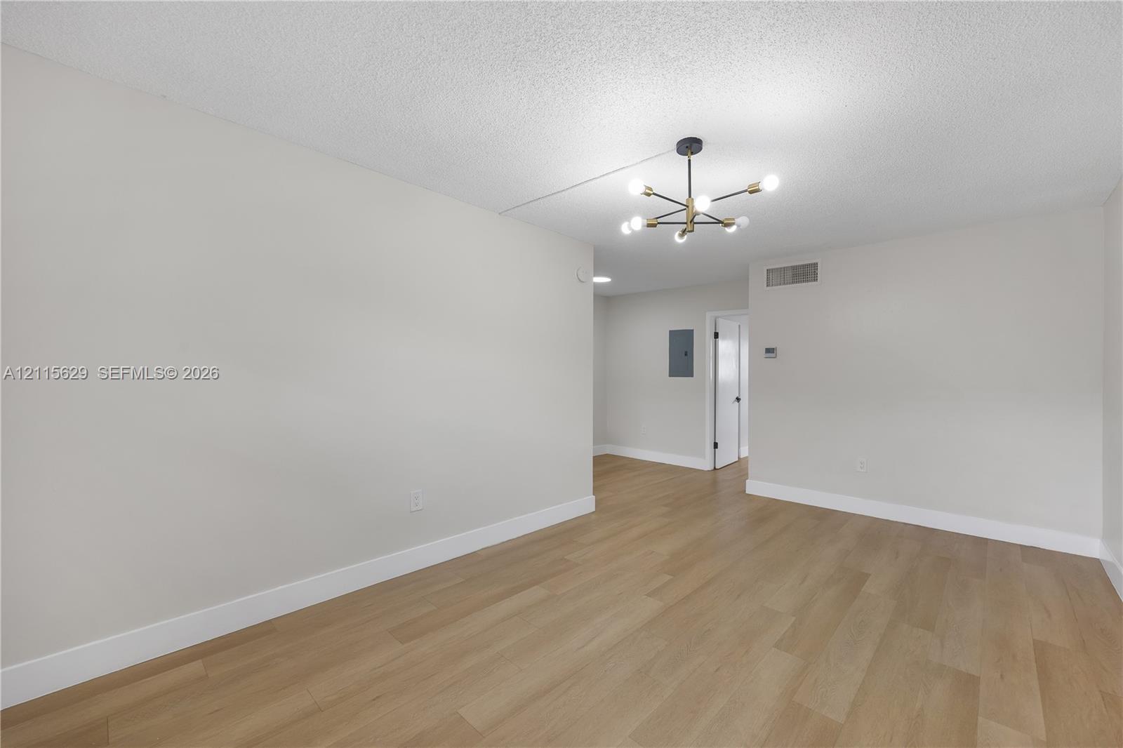 Interior space featuring wood-finish flooring, a contemporary multi-arm sputnik-style chandelier, and neutral wall tones