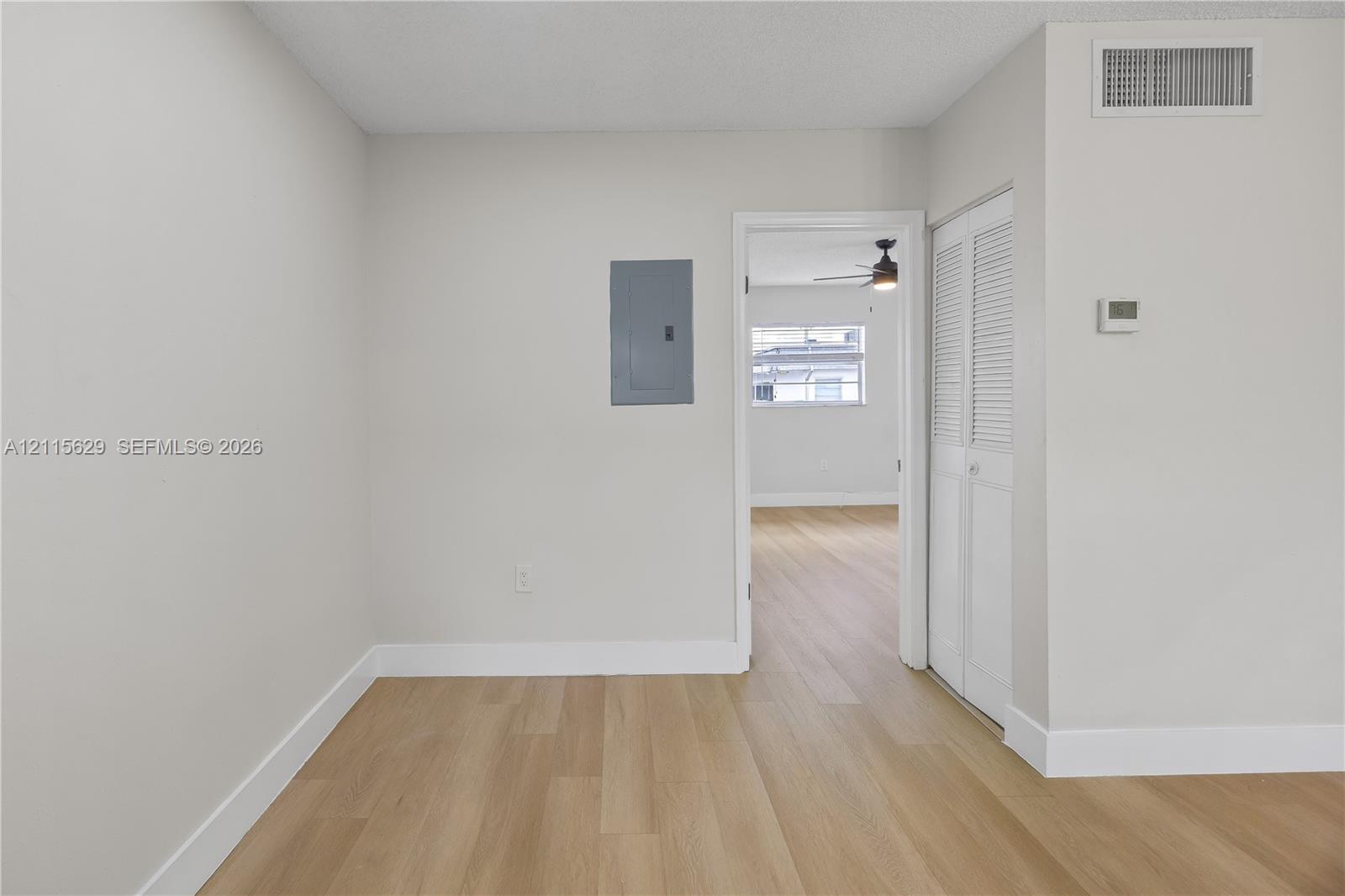 Neutral wall finishes, wood-finish flooring, and white louvered-style closet doors