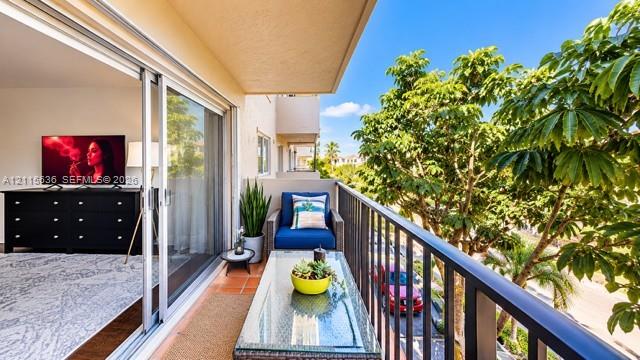 Private balcony featuring terracotta-style tile flooring and black metal railing