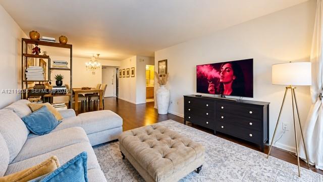 Open-concept interior featuring wood-finish flooring and a multi-arm crystal chandelier