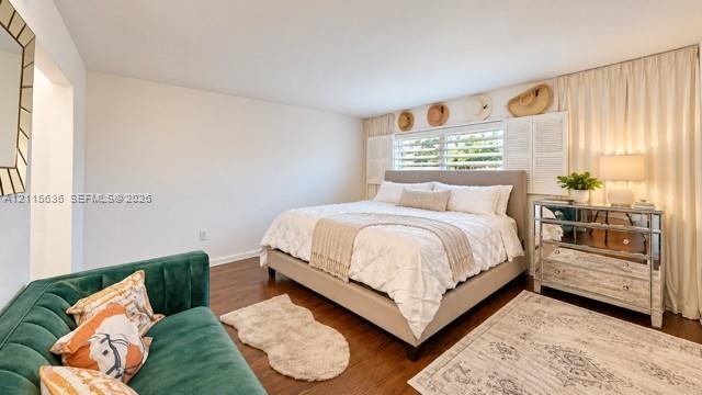 Wood-finish flooring, horizontal window blinds with louvered shutters, and ceiling-height window drapery