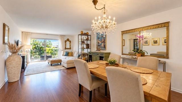 Wood-finish flooring, crystal-style chandelier, large decorative wall mirror with gold-tone frame, and sliding glass doors