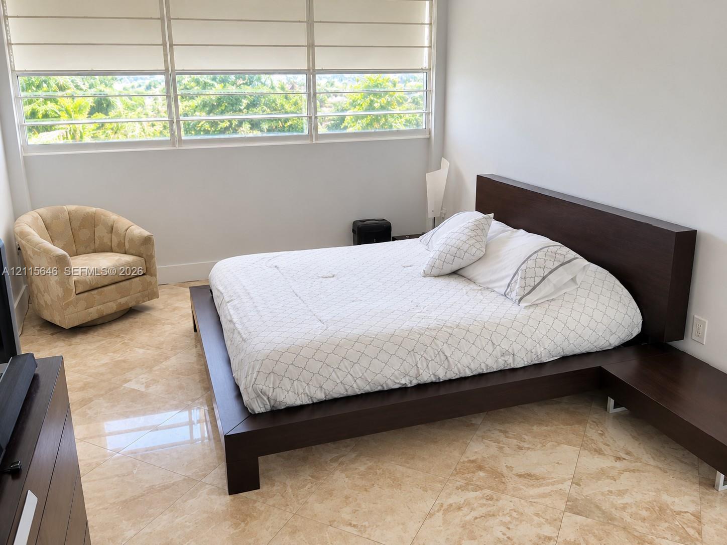 Polished stone flooring, expansive multi-pane horizontal windows, and adjustable fabric roller shades