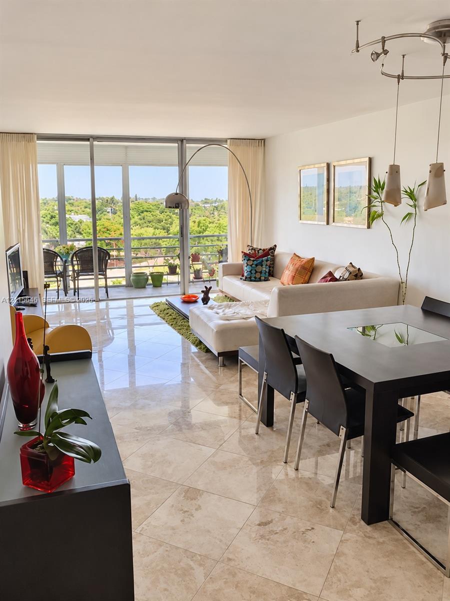 Large-format tile flooring, floor-to-ceiling sliding glass doors, and a private balcony featuring metal railings