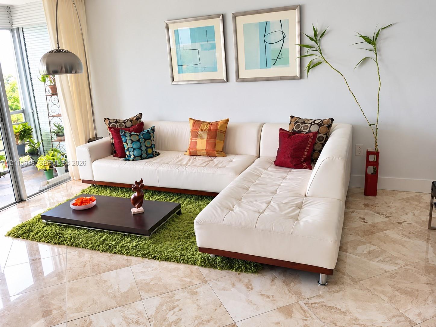 Large-format stone tile flooring, floor-to-ceiling glass sliding doors, and brushed metal dome pendant lighting