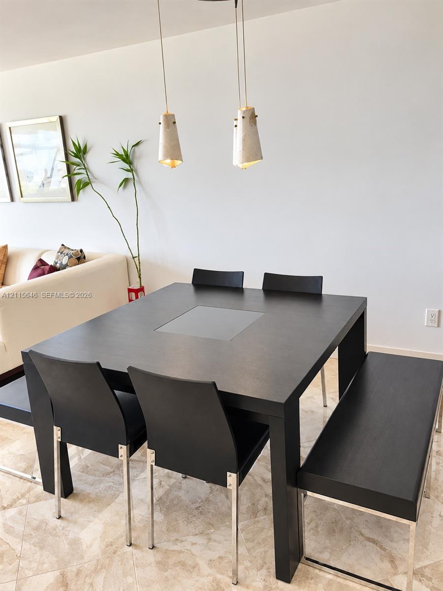 Dual cone-shaped pendant lights with metallic finish and neutral-toned stone flooring