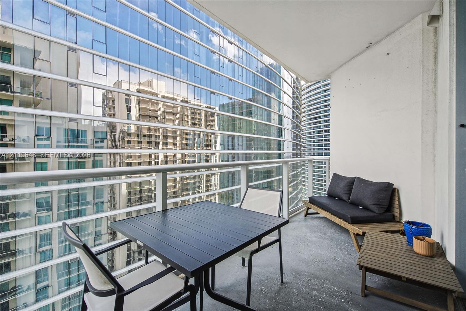 Covered balcony featuring concrete flooring and horizontal metal railings