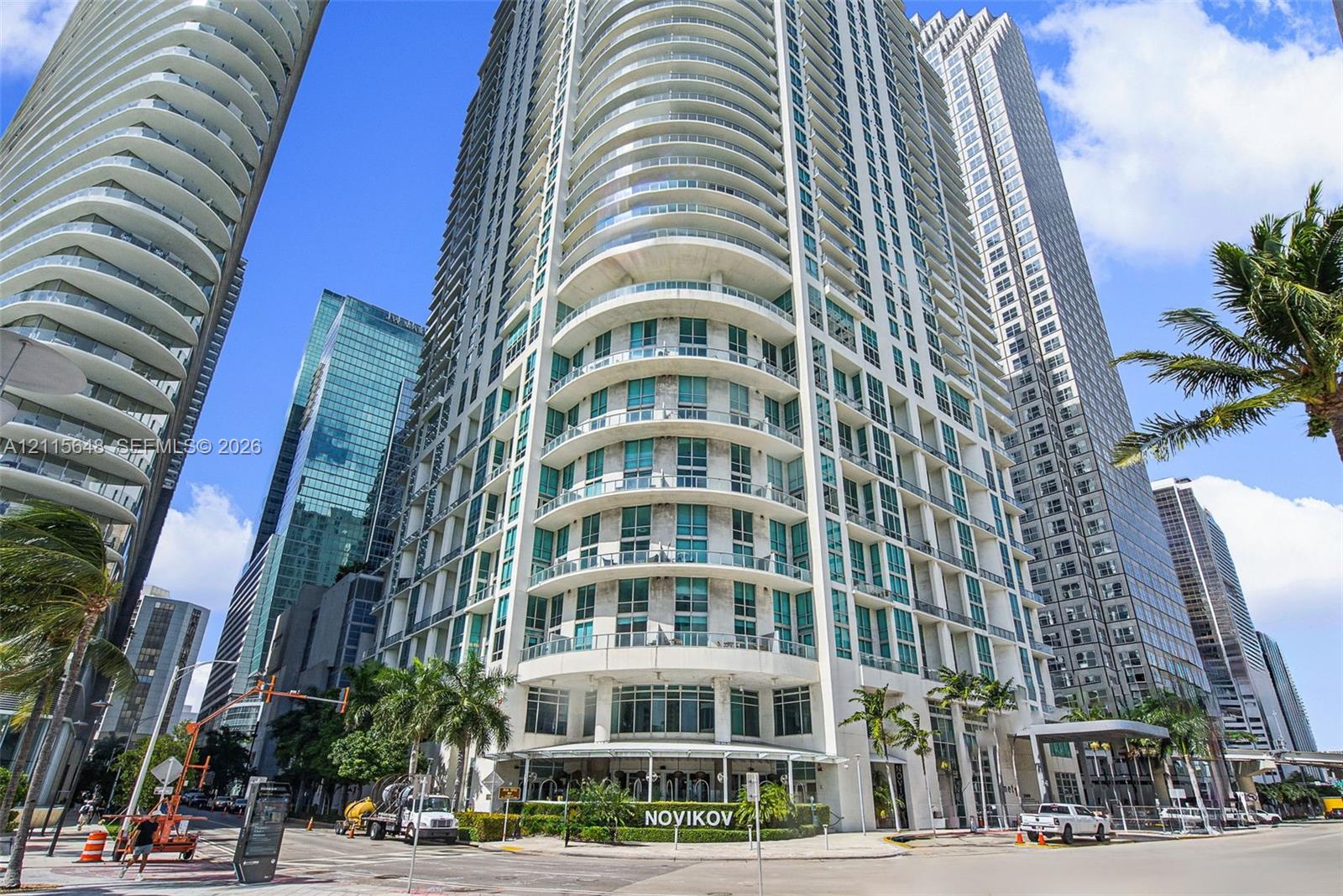 High-rise building exterior featuring curved architectural design, floor-to-ceiling glass windows, and wrap-around balconies