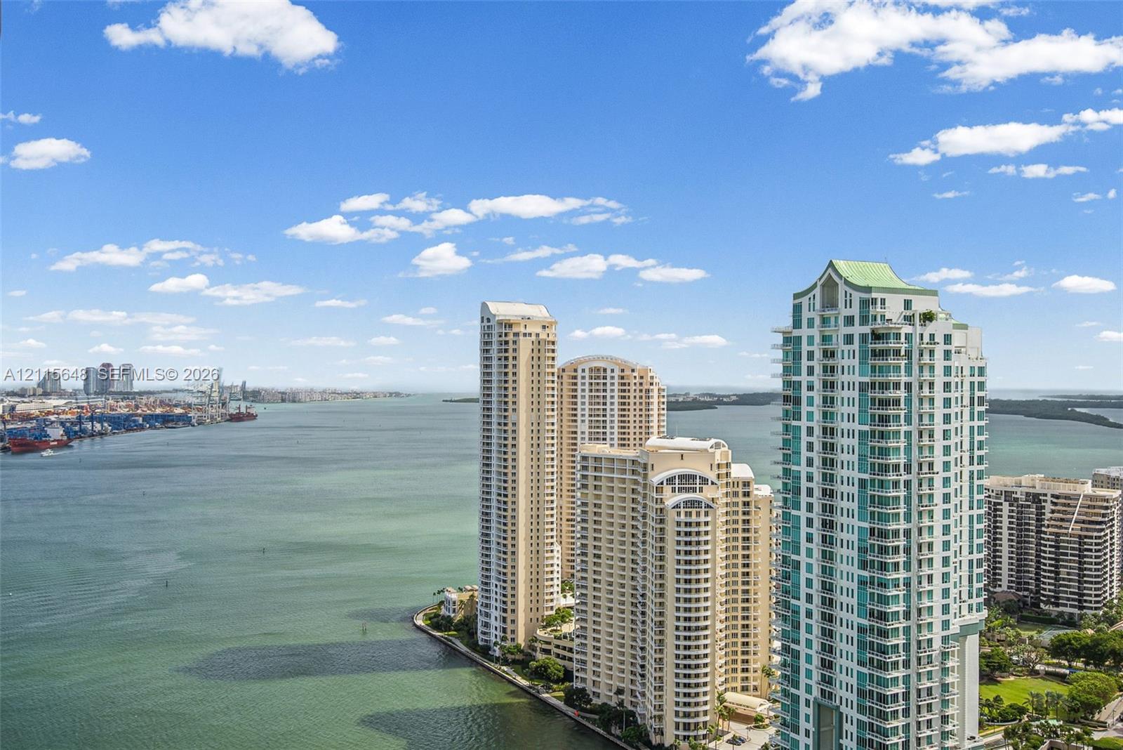 High-rise residential tower featuring balconies, floor-to-ceiling glass windows, a distinctive peaked roofline, and waterfront positioning