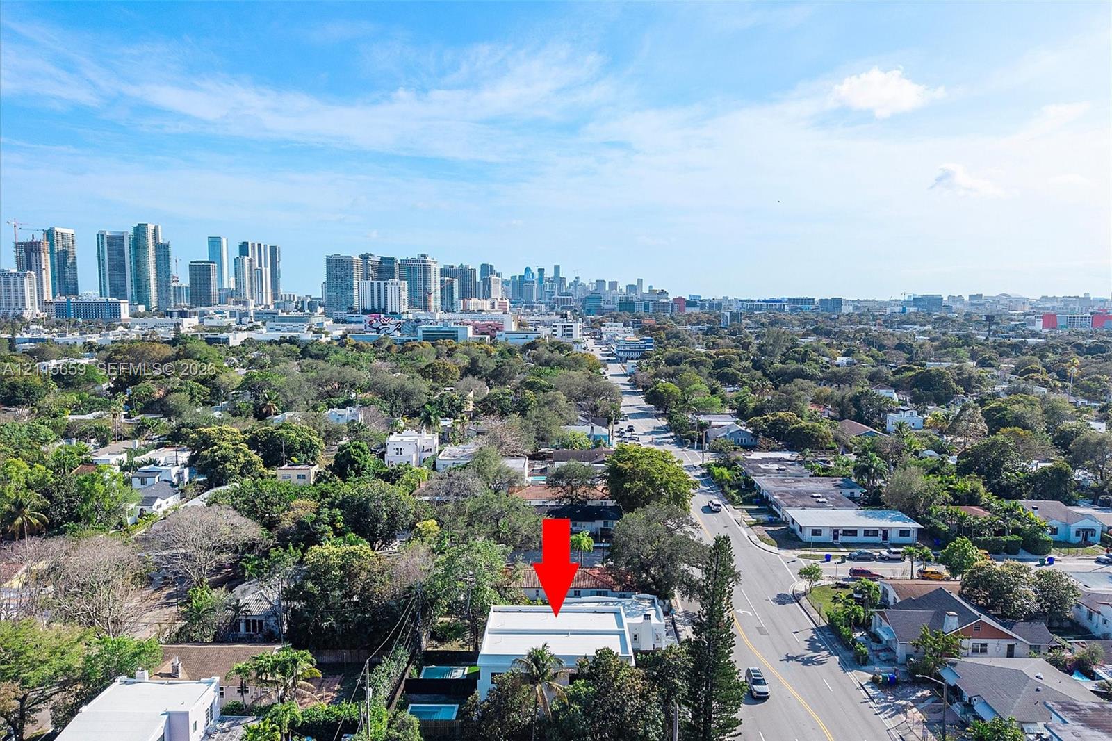 Aerial perspective of a detached residential property featuring a flat roof and a private pool, positioned within an urban landscape