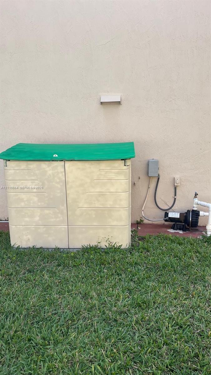 Exterior pump enclosure with a green lid, integrated motor, and dedicated electrical disconnect
