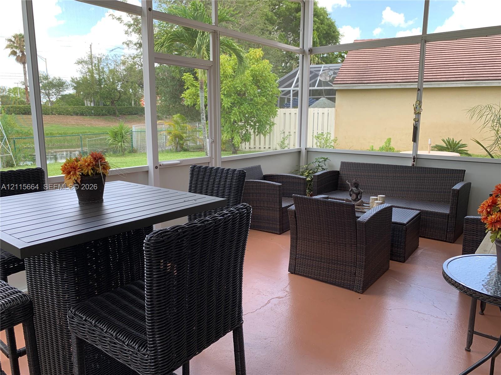 Screened-in lanai featuring a solid-surface floor, aluminum framing, and water-facing exposure