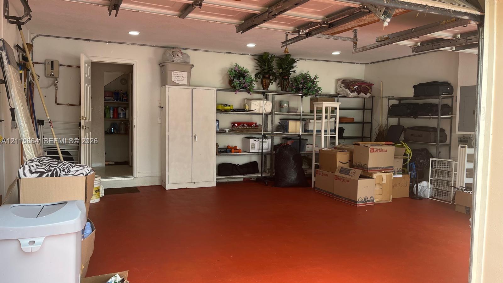 Multi-car garage featuring a painted concrete floor, recessed lighting, and a dedicated utility doorway