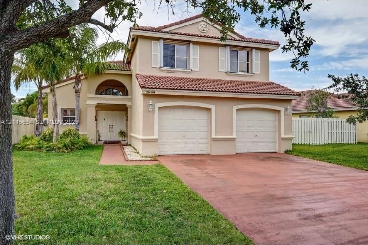 Two-story stucco exterior featuring a tile roof, dual-bay garage, arched entryway, and double front doors