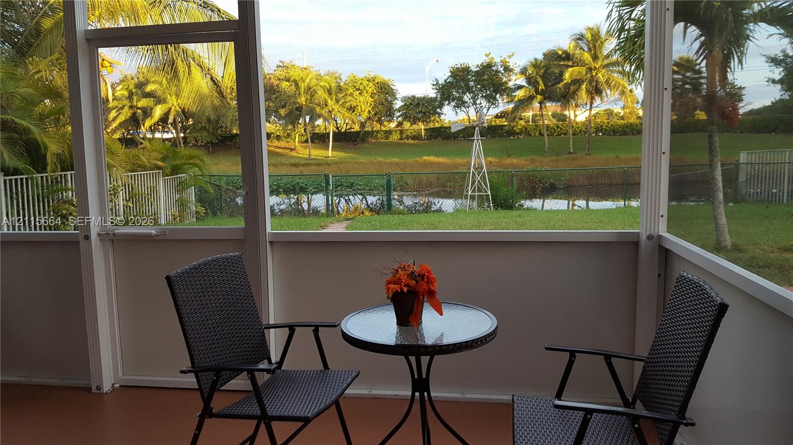 Screened-in patio featuring a solid-surface floor, aluminum framing, and water frontage