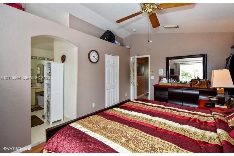 Vaulted ceilings featuring a polished brass ceiling fan and interior archway entrance