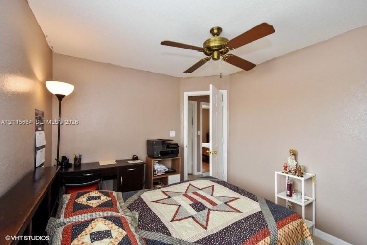 Interior room featuring a textured ceiling and a mounted brass-finish ceiling fan with wood-tone blades