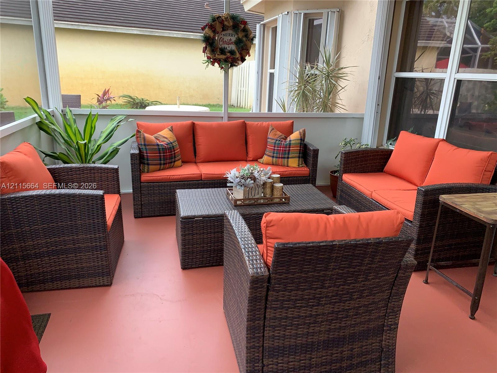 Enclosed lanai featuring a painted concrete floor, white structural framing, and full-height screen walls