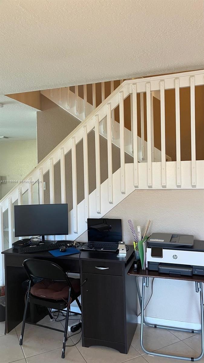 Staircase featuring white balusters and tile flooring
